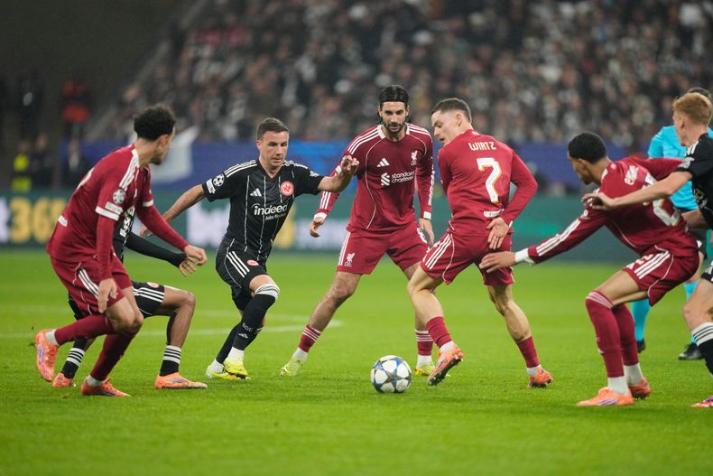 Mario Goetze, al centro izquierda, de Frankfurt, y Florian Wirtz (7) del Liverpool, disputan un balón durante el partido de fútbol de la Liga de Campeones entre Eintracht Frankfurt y Liverpool en Fráncfort, Alemania, el miércoles 22 de octubre de 2025. (AP Foto/Michael Probst)