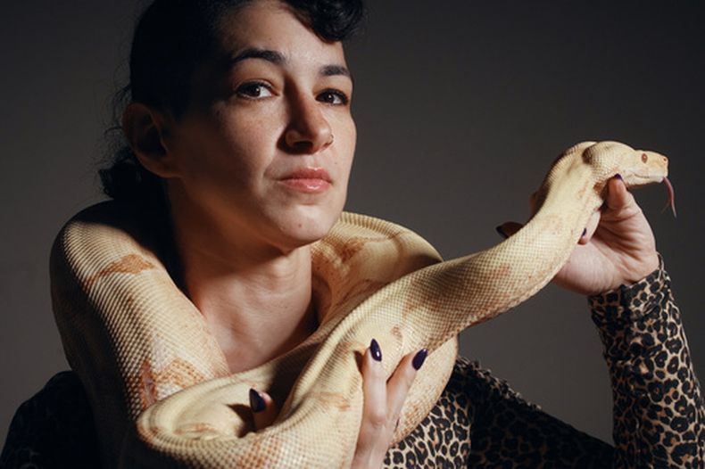 La artista Zoe Ziegfeld, que interpreta a una encantadora de serpientes, posa con una durante las audiciones para seleccionar una serpiente para un rol en la adaptación de Così fan tutte, de Mozart, en la Ópera Metropolitana de Nueva York, el 28 de agosto de 2026. (AP Foto/Andres Kudacki)