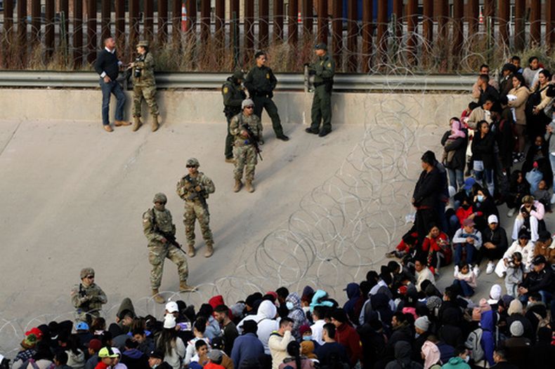 ARCHIVO - Migrantes reunidos en la orilla del río Bravo en la frontera de Estados Unidos con México, el 20 de diciembre de 2022, donde miembros de la Guardia Nacional de Texas cerraron un hueco en la cerca fronteriza de EEUU. (AP Foto/Morgan Lee, Archivo)