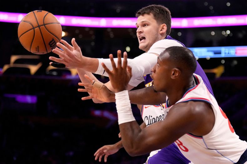Walker Kessler, pívot de los Lakers de Los Ángeles, disputa un balón con Kris Dunn, de los Clippers de la misma ciudad, el viernes 23 de octubre de 2026 (AP Foto/Mark J. Terrill)