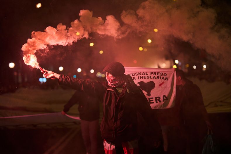 Un manifestante sostiene una bengala durante una protesta contra las acciones militares de Israel en Gaza, antes de un juego amistoso entre una selección de jugadores palestinos y un grupo de jugadores españoles del País Vasco, en Bilbao, España, el sábado 15 de noviembre de 2025. (AP Photo/Miguel Oses)