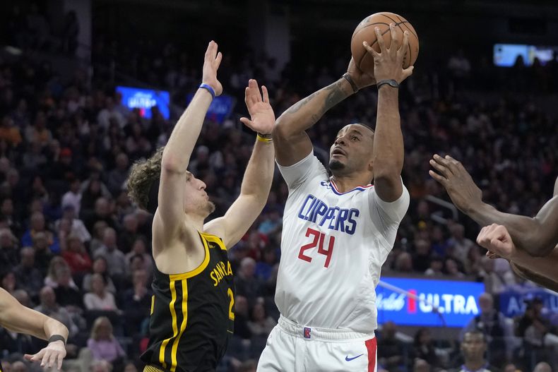 Norman Powell, base de los Clippers de Los Ángeles, dispara frente a Brandin Podziemski, de los Warriors de Golden State en el encuentro del miércoles 14 de febrero de 2024 (AP Foto/Jeff Chiu)
