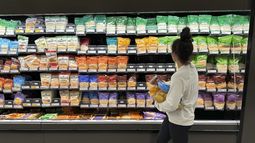ARCHIVO - Una mujer revisa las ofertas de quesos en una tienda de la cadena Target, el 4 de octubre de 2023, en Sheridan, Colorado. (AP Foto/David Zalubowski, archivo)