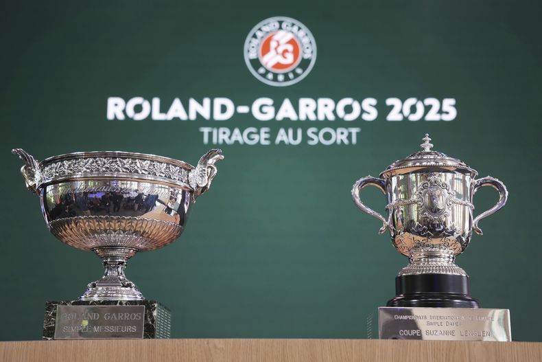 Los trofeos masculino, izquierdo y femenino se exhiben durante el sorteo del torneo de tenis Abierto de Francia, el jueves 22 de mayo de 2025 en el estadio Roland Garros de París. (AP Foto/Christophe Ena)