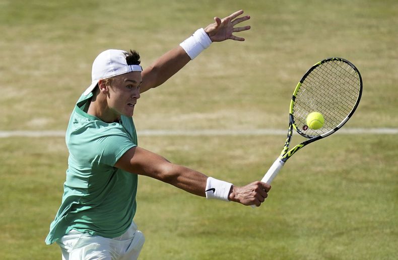 El danés Holger Rune regresa un tiro del italiano Lorenzo Musetti en los cuartos de final del Queens Club championship en Londres el viernes 23 de junio del 2023. (Adam Davy/PA via AP)
