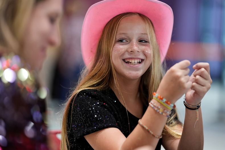 Hazel Gilbert, de 10 años, construye una pulsera de la amistad durante una fiesta de lanzamiento del nuevo álbum de Taylor Swift, The Life of a Showgirl, en un cine el viernes 3 de octubre de 2025, en Nashville, Tennessee. (Foto AP/George Walker IV)