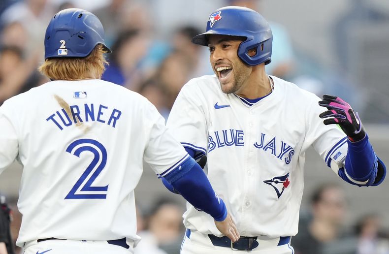 George Springer, de los Azulejos de Toronto, festeja con Justin Turner tras conectar un jonrón de tres carreras en la primera entrada del juego ante los Yankees de Nueva York, el jueves 27 de junio de 2024 (Frank Gunn/The Canadian Press via AP)