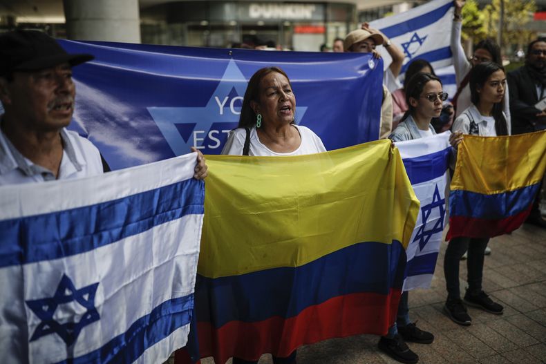 Personas con las banderas de Colombia e Israel, como muestra de apoyo, en una concentración frente a la embajada israelí en Bogotá, Colombia, el lunes 9 de octubre de 2023, dos días después del ataque mortal de Hamas a Israel. (AP Foto/Iván Valencia)