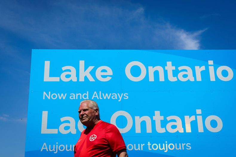 El primer ministro de Ontario, Doug Ford, muestra un letrero del lago Ontario en el área de conservación Fifty Point en Grimsby, Ontario, Canadá, el sábado 29 de agosto de 2026. (Keito Newman/The Canadian Press vía AP)