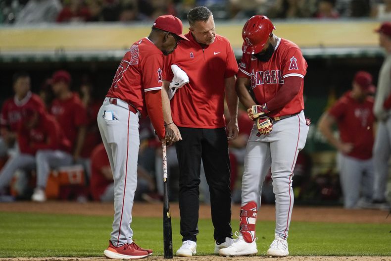 El venezolano de los Angelinos de Los Ángeles Luis Rengifo se toma la mano tras sufrir una lesión en la novena entrada del juego ante los Atléticos de Oakland el miércoles 3 de julio del 2024. (AP Foto/Godofredo A. Vásquez)
