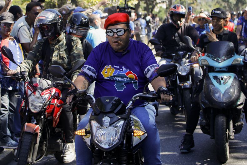 Partidarios del gobierno pasan junto a opositores del presidente venezolano Nicolás Maduro que protestan el día antes de su toma de posesión para un tercer mandato en Caracas, Venezuela, el jueves 9 de enero de 2025. (AP Foto/Cristian Hernández)