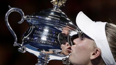 ARCHIVO - Caroline Wozniacki besa el trofeo de campeona del Abierto de Australia tras derrotar a Simona Halep en la final, el sábado 27 de enero de 2018. (AP Foto/Dita Alangkara)