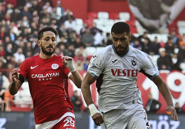 El jugador del Antalyaspor Sagiv Jehezkel, a la izquierda, lucha por el balón con el jugador del Trabzonspor Rayyan Baniya durante un partido de la Superliga turca en Anta Antalyaspor and Trabzonspor in Antalya, en el sur de Turquía, el domingo 14 de enero de 2024. (Cafer Eser/IHA via AP)