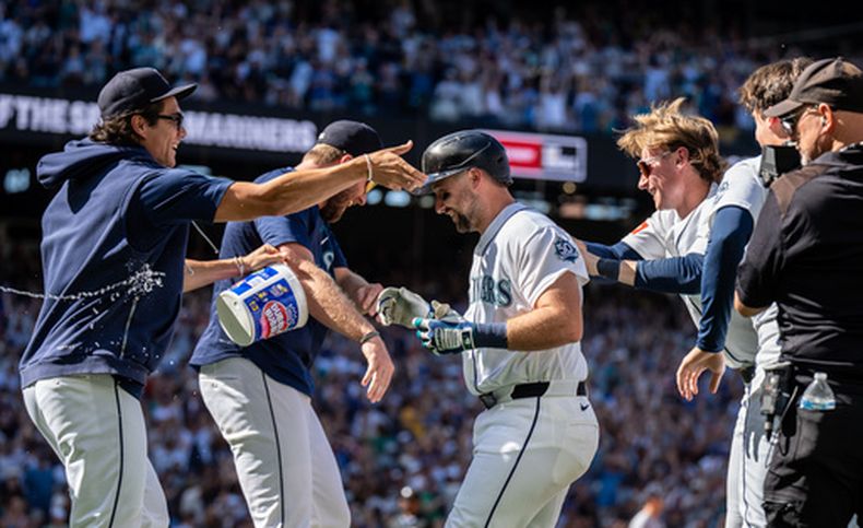 Los Marineros de Seattle, incluidos Bryan Woo (izquierda), Cal Raleigh (centro) y Colt Emerson (tercero desde la derecha), celebran tras un partido de béisbol contra los Mellizos de Minnesota, el sábado 1 de agosto de 2026, en Seattle. (Foto AP/Stephen Brashear)