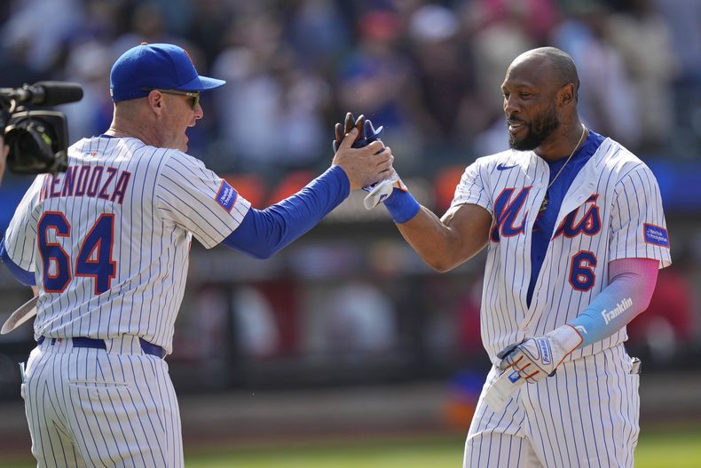 El mánager de los Mets de Nueva York Carlos Mendoza celebra con el dominicano Starling Marte su sencillo remolcador en la décima ante los Filis de Filadelfia el miércoles 23 de abril del 2025. (AP Foto/Seth Wenig)