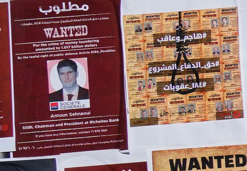 Un cartel falso de “Se busca” del banquero libanés Antoun Sehnaoui, izquierda, colocado por manifestantes fuera del Banco Central Libanés en Beirut, Líbano, el viernes 19 de enero de 2024. Más de una docena de abogados libaneses presentaron una queja ante la fiscalía de Líbano en Beirut el miércoles 29 de julio de 2026 contra el prominente banquero local afirmando que violó las leyes del país al reunirse con el primer ministro israelí Benjamin Netanyahu en Washington esta semana. (AP Photo/Hussein Malla)