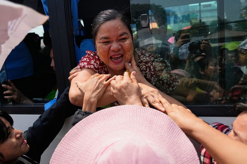 Prisioneros liberados, en un bus, son recibidos por familiares y colegas tras su salida de la cárcel de Insein, en Yangón, Myanmar, el 17 de abril de 2026, tras la amnistía del presidente del país para conmemorar el inicio de año. (AP Foto/Thein Zaw)
