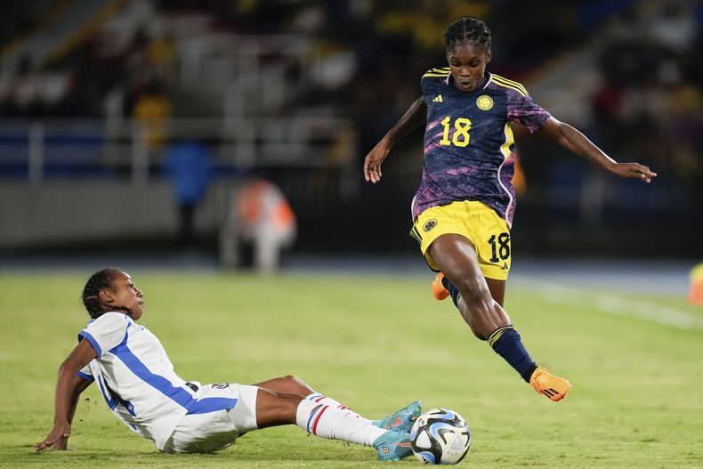 La delantera colombiana Linda Caicedo (18) salta sobre la panameña Erika Hernández en un partido amistoso rumbo al Mundial femenino, el miércoles 21 de junio de 2023, en Cali, Colombia. (AP Foto/Fernando Vergara)