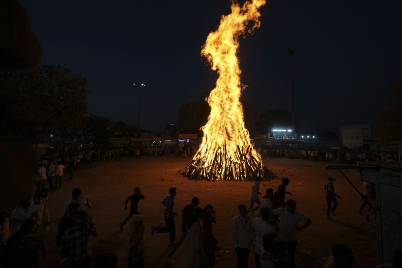Un grupo de personas practican rituales alrededor del fuego sagrado, llamado Holi ka dahan, durante la celebración del Holi en la localidad de Palaj, cerca de Gandhinagar, India, el 13 de marzo de 2025. (AP Foto/Ajit Solanki)