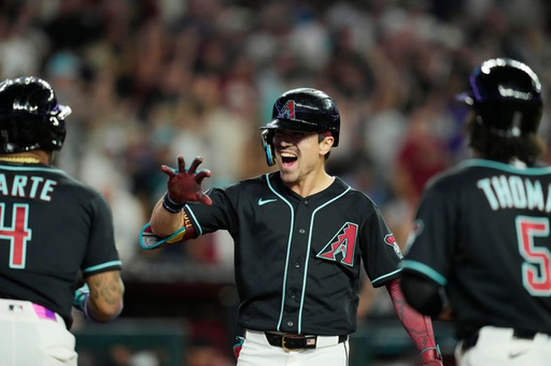 Corbin Carroll de los Diamondbacks de Arizona celebra con Ketel Marte y Alek Thomas su grand slam en la octava ante los Azulejos de Toronto el sábado 18 de abril del 2026. (AP Foto/Ross D. Franklin)