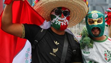 Aficionados mexicanos con máscaras llegan a una fiesta cerca del Ángel de la Independencia en la capital de su país, el domingo 5 de julio de 2026 (AP Foto/Ginnette Riquelme)