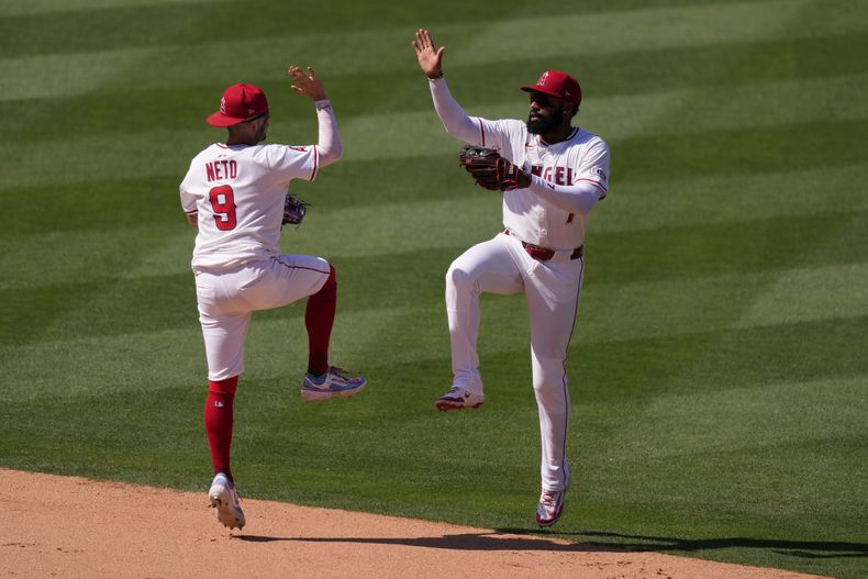 Zach Neto felicita a su compañero de los Angelinos de Los Ángeles Jo Adell tras la victoria ante los Atléticos el miércoles 11 de junio del 2025. (AP Foto/Mark J. Terrill)