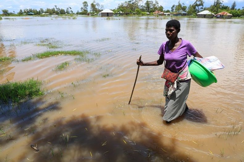 Una mujer camina por una zona inundada tras las fuertes lluvias en Nyakach, en el oeste de Kenia, el martes 24 de marzo de 2026. (Foto AP/Andrew Kasuku)