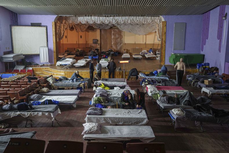 Gente sentada en camas tras ser evacuada del frente en un centro para desplazados en Pavlohrad, Ucrania, el sábado 1 de febrero de 2024. (AP Foto/Evgeniy Maloletka)