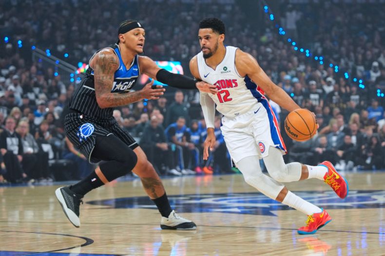 Tobias Harris (12), de los Pistons de Detroit, lleva el balón frente a Paolo Banchero (5), del Magic de Orlando, durante la primera mitad del sexto juego de la serie de primera ronda de los playoffs del baloncesto de la NBA, el viernes 1 de mayo de 2026, en Orlando, Florida. (AP Foto/John Raoux)