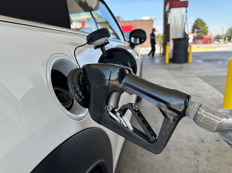 Un automovilista llena el tanque de combustible de un vehículo, mientras otro hace lo mismo en el fondo en una gasolinería QT, el miércoles 12 de agosto de 2026, en Greenwood Village, Colorado. (AP Foto/David Zalubowski)