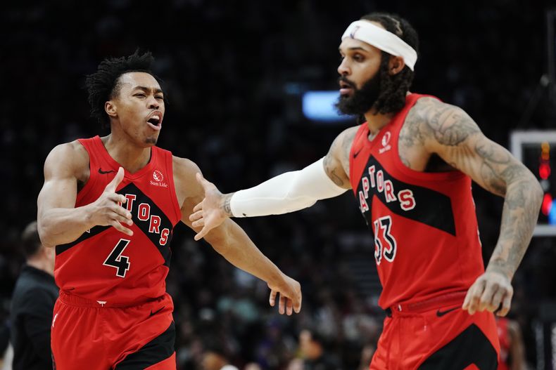 Scottie Barnes (4) y Gary Trent Jr. (33), de los Raptors de Toronto, celebran una canasta en contra del Heat de Miami durante la segunda mitad del juego de baloncesto de la NBA, el miércoles 17 de enero de 2024, en Toronto. (Frank Gunn/The Canadian Press vía AP)