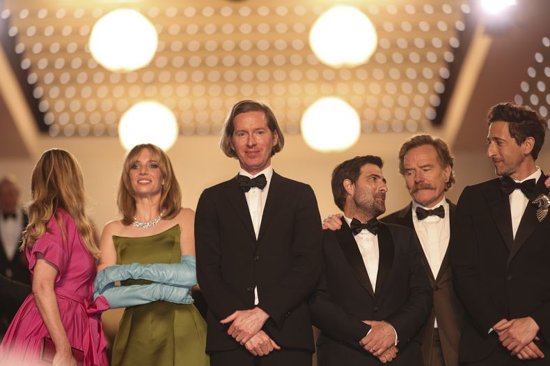 Hope Davis, de izquierda a derecha, Maya Hawke, el director Wes Anderson, Jason Schwartzman, Bryan Cranston y Adrien Brody posan al salir del estreno de Asteroid City en la 76a edición del Festival de Cine de Cannes, en el sur de Francia el 23 de mayo de 2023. (Foto Vianney Le Caer/Invision/AP)