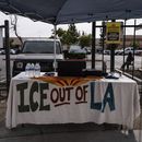 Una mesa cubierta con un mantel en el que se lee ICE fuera de Los Ángeles se encuentra bajo un toldo junto al centro de empleo para jornaleros, afuera de una tienda Home Depot en el barrio de Van Nuys, en Los Ángeles, el 28 de agosto de 2025. (AP Foto/Jae C. Hong)
