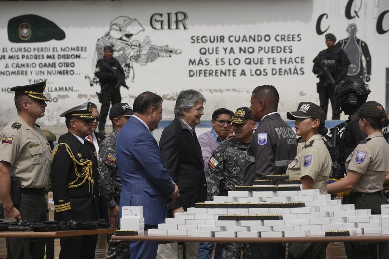 El presidente de Ecuador, Guillermo Lasso, entrega municiones a agentes en una sede policial en Quito, Ecuador, el jueves 27 de julio de 2023. La policía hizo una demostración de una operación contra el crimen organizado en la ceremonia. (AP Foto/Dolores Ochoa)