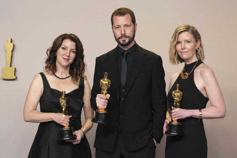 Raney Aronson-Rath, de izquierda a derecha, Mstyslav Chernov, y Michelle Mizner posan en la sala de prensa con el premio a mejor largometraje documental por 20 Days in Mariupol en los Oscar el domingo 10 de marzo de 2024, en el Teatro Dolby en Los Ángeles. (Foto Jordan Strauss/Invision/AP)