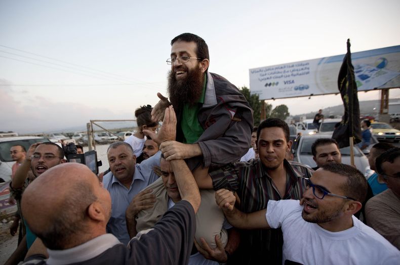 ARCHIVO - El palestino Khader Adnan, en el centro, es recibido por palestinos tras su liberación de una prisión israelí en el poblado cisjordano de Arrabeh, cerca de Yenín, el domingo 12 de julio de 2015. Adnan, que estaba en prisión en Israel, murió el martes 2 de mayo de 2023 tras casi tres meses en huelga de hambre, según anunció el servicio de penales israelíes. (AP Foto/Majdi Mohammed, Archivo)
