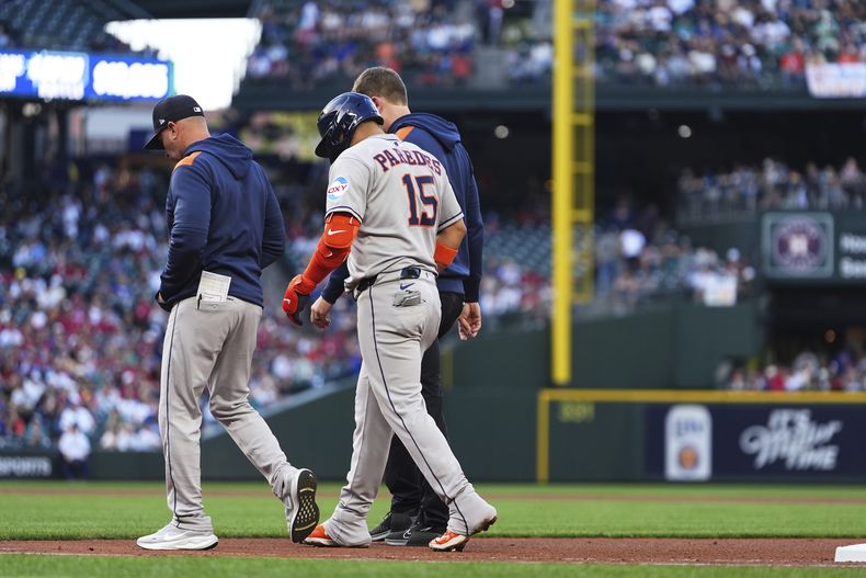 Isaac Paredes (15), de los Astros de Houston, camina de regreso al dugout del equipo con una aparente lesión que sufrió después de correr a primera base en un sencillo frente a los Marineros de Seattle durante la tercera entrada del juego de béisbol de Grandes Ligas, el sábado 19 de julio de 2025, en Seattle. (AP Foto/Lindsey Wasson)