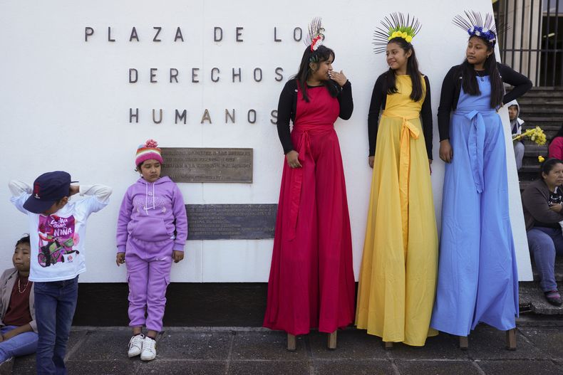 Tres mujeres en zancos en la plaza de los Derechos Humanos para el inicio de la marcha por el Día de la Erradicación de la Violencia contra las Mujeres en Ciudad de Guatemala, el lunes 25 de noviembre de 2024. (AP Foto/Moisés Castillo)