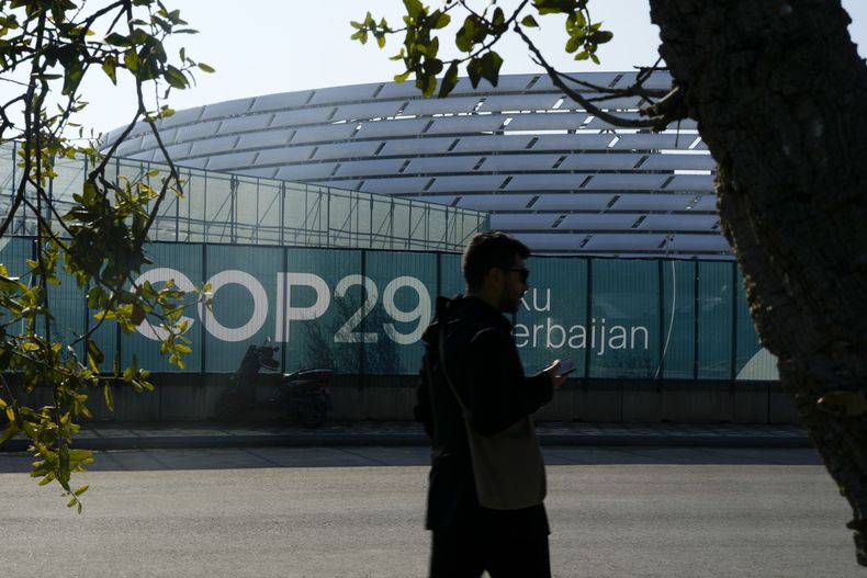 Una persona camina por el exterior del Estadio Olímpico de Bakú, la sede de la cumbre climática de Naciones Unidas COP29, el 10 de noviembre de 2024, en Bakú, Azerbaiyán. (AP Foto/Rafiq Maqbool)