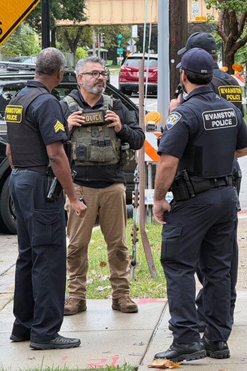 Esta foto, proporcionada por Ryan Garton, muestra a un agente federal hablando con policías el domingo 20 de septiembre de 2026, en Evanston, Illinois. (Ryan Garton vía AP)