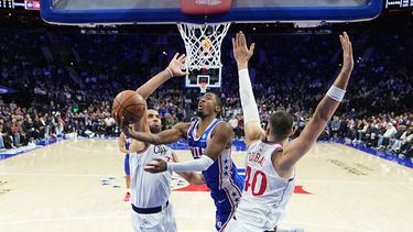 Tyrese Maxey, centro, de los 76ers de Filadelfia, se alza para encestar entre Nicolas Batum, izquierda, e Ivica Zubac, derecha, de los Clippers de Los Ángeles, durante la segunda mitad del juego de baloncesto de la NBA, el lunes 17 de noviembre de 2025, en Filadelfia. (AP Foto/Matt Rourke)