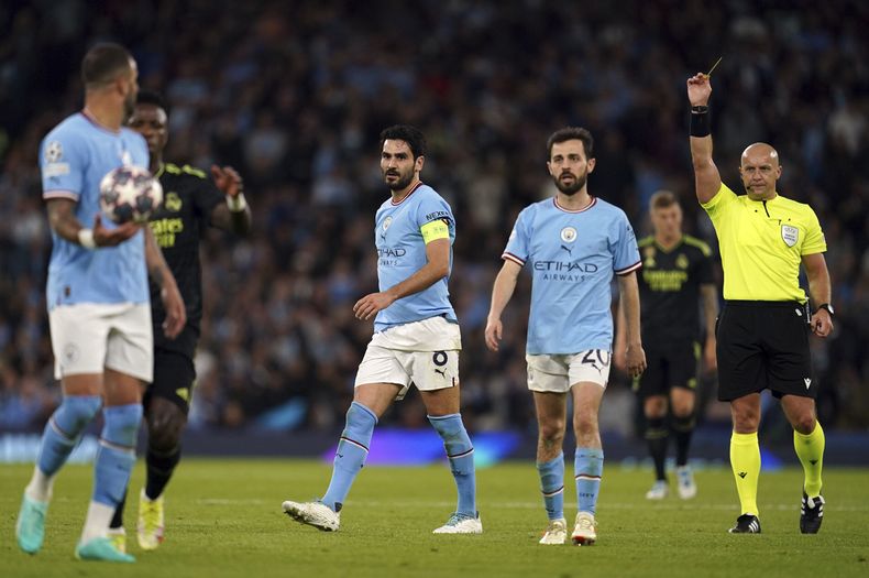 Ilkay Gundogan del Manchester City es amonestado por el árbrito Szymon Marciniak (derecha) durante el partido contra el Real Madrid por las semifinales de la Liga de Campeones, el miércoles 17 de mayo de 2023. (Nick Potts/PA vía AP)