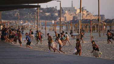 Varias personas abandonan una playa en Tel Aviv, Israel, el miércoles 18 de junio de 2025, luego de que se activó la alarma de misiles. (AP Foto/Ohad Zwigenberg)