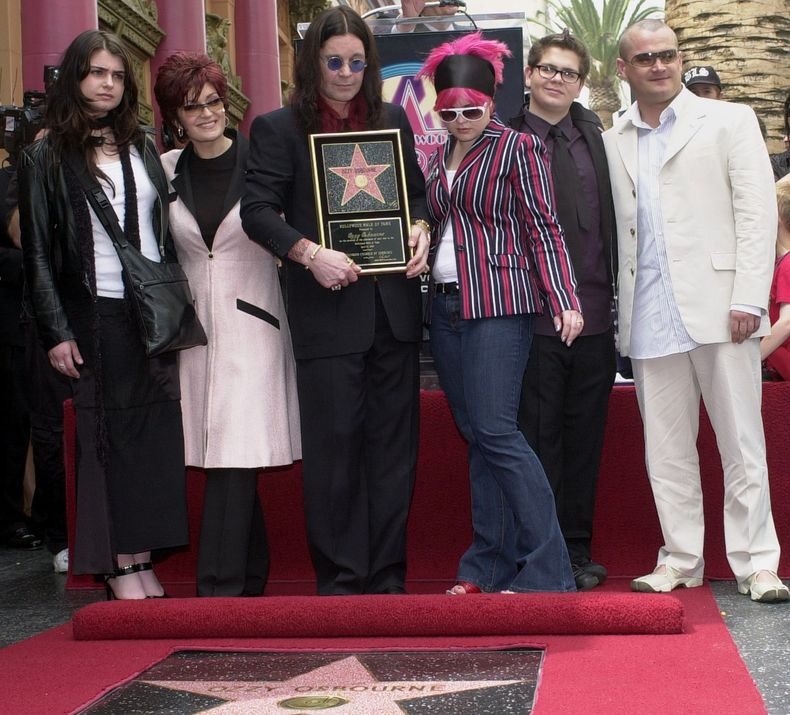 ARCHIVO - El astro del metal Ozzy Osbourne sostiene una réplica de su nueva estrella en el Paseo de la Fama de Hollywood mientras posa con su familia durante una ceremonia el 12 de abril de 2002 en Los Ángeles. En la foto, de izquierda a derecha, aparecen Aimee, Sharon, Kelly, Jack y Louis. (Foto AP/Nick Ut, archivo)