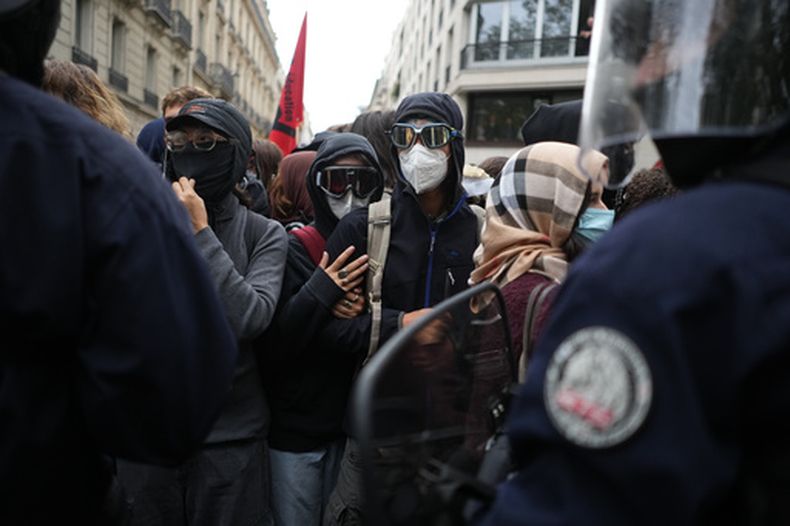 Estudiantes se enfrentan a agentes de la policía cerca de la Universidad de Ciencias Políticas durante una protesta contra la falta de financiamiento de las escuelas públicas, en París, el 7 de octubre de 2026. (AP Foto/Thibault Camus)
