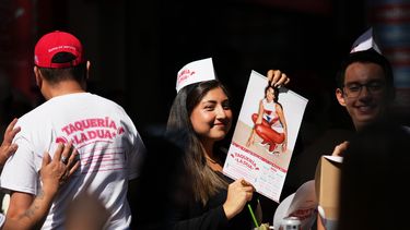 Una clienta sostiene un calendario de Dua Lipa durante la apertura la taquería La Dua de la estrella de la música, un restaurante emergente para sus fans en la Ciudad de México, el lunes 1 de diciembre de 2025. (Foto AP/Eduardo Verdugo)