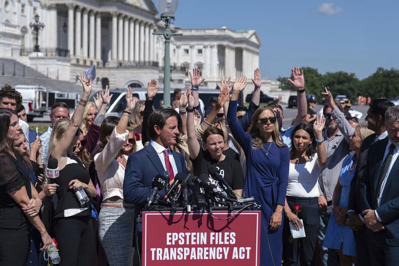 Asistentes levantan las manos para presionar al Congreso a que publique documentos relacionados con Jeffrey Epstein durante una conferencia de prensa en el Capitolio, el miércoles 3 de septiembre de 2025, en Washington. (AP Foto/Jose Luis Magana)