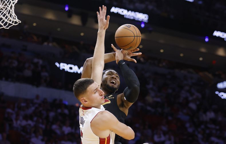 El alero del Heat de Miami Nikola Jovic defiende al base de los Cavaliers de Cleveland Donovan Mitchell en el juego 4 de la serie de primera ronda de los platoffs el lunes 28 de abril del 2025. (AP Foto/Rhona Wise)