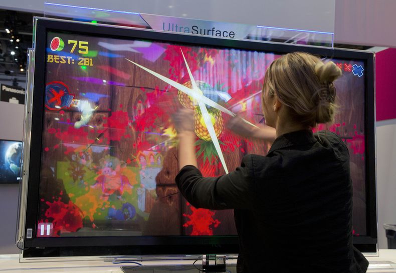Foto tomada el 10 de enero del 2013 de una joven jugando Fruit Ninja en una feria de juegos electr&oacute;nicos en Las Vegas.  (AP Photo/Julie Jacobson, File)