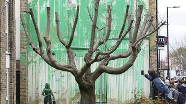 Personas miran un nuevo mural de Banksy en una pared en Londres, el lunes 18 de marzo de 2024. Un nuevo mural de Banksy en el vecindario de Finsbury Park atrajo multitudes a una calle de Londres el lunes, incluso antes de que el esquivo artista de graffiti confirmara que la obra era suya. (Foto AP/Alastair Grant)